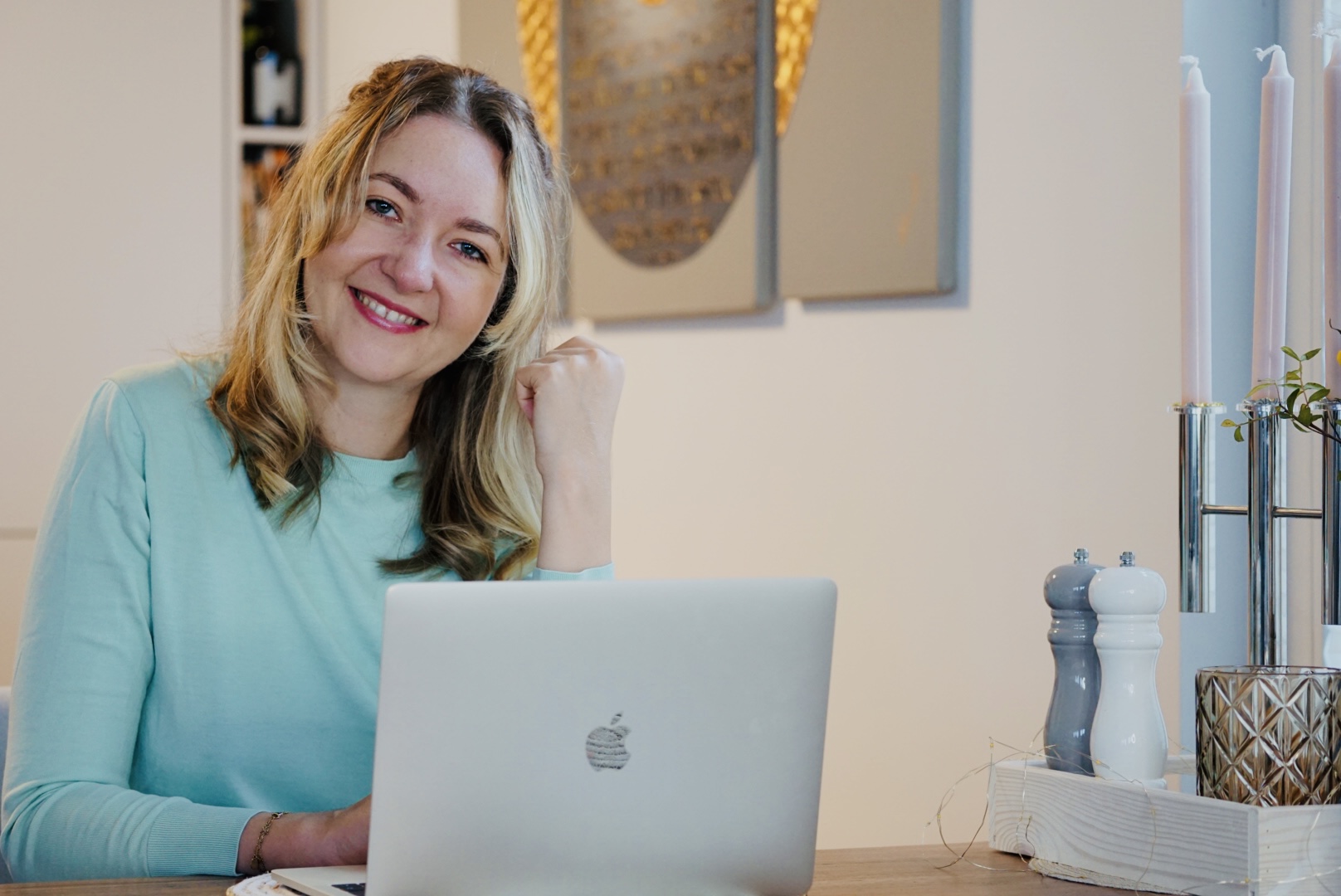 Isabel von Göler lächelt am Laptop, im Hintergrund warmes Wohnzimmerlicht